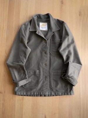Olivgrön overshirt från Le Mont St Michel - Nice cotton Chore Coat / Overshirt.   Measurements are shown in the picture. (Pit to pit, arm length and length from top shoulder) Size: (40, but fits like S)   Shipping & Delivery • Buyer pays for shipping (cost depends on selected shipping method). • I am not responsible for the postal service once the package has been handed over. • Combined shipping is available when purchasing multiple items.