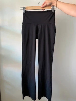 Svarta yoga leggings  - Säljer ett par svarta utsvängda  leggings från OTP. Byxorna har hög midja och stretchigt material som sitter skönt. Köpta på gekås Ullared. Storlek xs 32/34 kort längd. Använda en gång. 