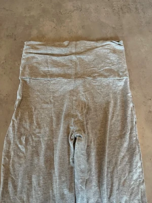 Grå yoga pants - Säljer ett par grå yoga pants och stretchigt material. De har en enkel och stilren design utan synliga loggor eller detaljer. Perfekta för en avslappnad look och passar till det mesta i garderoben.