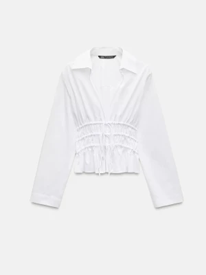 Blus med krage och markerad midja🌟 - Trendig vit croppad blus med långa ärmar och markerad midja med snörning framtill. Blusen har en bred krage och är tillverkad i ett lätt, vävt material som ger en avslappnad men snygg look.