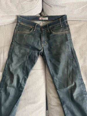 Levis jeans 504 straight  - Säljer dessa Levis jeans i modellen 504 straight. Är osäker på storleken men skulle säga att de sitter som 32/32. Använt ett par gånger men modellen skall också vara lite sliten. Ett litet hål på jeansen som är mellan benen(se sista bilden) men är väldigt enkelt att sy igen. Kan gå ner i pris vid en snabb och smidig affär! Köparen står för frakten😁