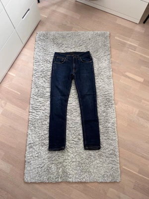 Mörkblå Nudie Jeans - Säljer ett par mörkblå Nudie jeans i modellen Lean Dean och storlek W31 L32. Modellen på bilden är ca 167cm och 54kg. De har feta fades och är i grymt skick! Tveka inte att skriva vid funderingar eller intresse.