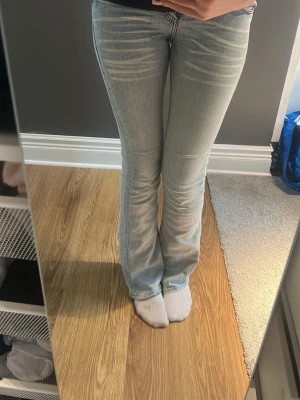 Cheap monday Ljusblå bootcut jeans - Säljer ett par ljusblå cheap monday bootcut jeans med snygga slitningar framtill. Jeansen har klassisk femficksdesign och normal midja. Det står storlek i bilden: 26 i midja och 34 i längd, säljer för att jag aldrig använt dem eftersom jag köpte en storlek för litet.