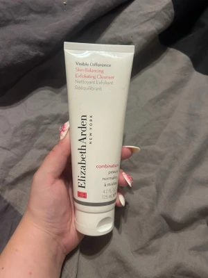 Elizabeth Arden exfolierande rengöring - Exfolierande rengöring från Elizabeth Arden för normal till kombinerad hud. Tuben är vit med svart och röd text och innehåller 125 ml. Perfekt för dig som vill ha en balanserad och fräsch hudkänsla.