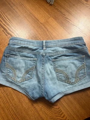 Lågmidjade jeans shorts Hollister - Säljer ett par jättesnygga blå jeansshorts från Hollister med snygga bakfickor och kontrastsömmar. Ultra low waist och passar mig som har S, midjemått 36/37cm! 