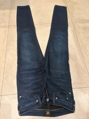Jeans från Lee - Mörkblå jeans från Lee i modellen Scarlett. Storlek W26 L33. 