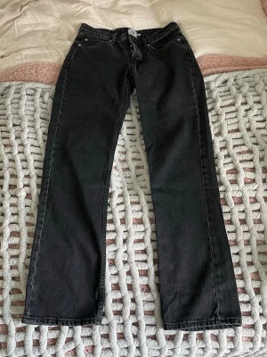 Svarta raka jeans - Säljer ett par svarta jeans med rak passform och klassisk femficksdesign. Jeansen har normal midja. Knappt använda. 