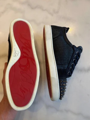 Mörkblå sneakers med nitar - Säljer ett par Christian Louboutin skor som är marinblåa! Få effekter på skorna och de ser ut som nya på avstånd. Box ingår tyvärr inte:( köpte dessa på Vinted och har själv bara använt dem under student veckan (3-5ggr)🥂😁