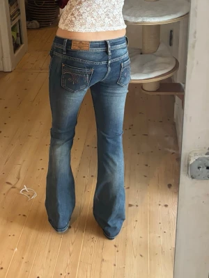 Lowwaist bootcut jeans med diamanter - Supersnygga lowwaist bootcut vintage jeans med diamanter/ strass på fickorna. Har köpt på humana och märker är premium jeans Monday. Fina guldsömmar. I superskick förutom liten söm som har lyfts (se bild) men den är bara för utseendet skull så jeansen går inte sönder om den lossnar. Det står stl L men jag på bilden har S/xs Hör av er för fler bilder eller frågor🩷