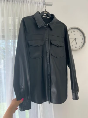 Jacka/shacket i fuskläder - En helsvart shacket i fuskläder från NA-KD. Använd en handfull gånger - nyskick! True to size - passar bra till 36/38.  Perfekt med en kofta under nu till hösten 🧥🍁