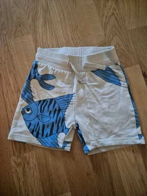 Mini Rodini blå fiskar - Mini Rodini shorts, stl 80-86. Fint skick. Hos oss bor inga djur eller rökare.