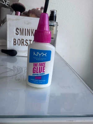 NYX The Face Glue Gripping Primer - NYX The Face Glue Gripping Primer är en vit primer i plastflaska med rosa kork. Den har en klistrig formula som hjälper sminket att sitta hela dagen. Flaskan rymmer 35 ml och har en praktisk spets för enkel applicering. Perfekt för dig som vill ha en hållbar bas.