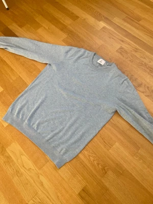 Ljusblå tröja från Bläck - Ljusblå tröja från Bläck i mjukt material. Klassisk rund halsringning och ribbade muddar vid ärmslut och nederkant. Enkel och stilren design som passar till det mesta. Knappt använd.