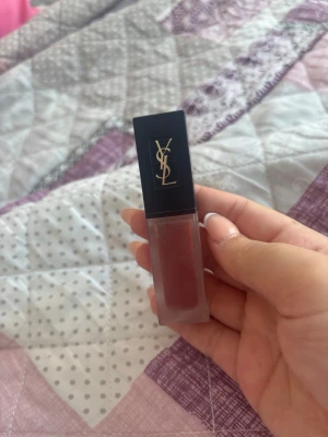 YSL läppglans i varm brunröd nyans - Snyggt läppglans från Yves Saint Laurent i en varm brunröd färg. Kommer i en stilren fyrkantig förpackning med svart lock och guldigt YSL-logo. Applikatorn är mjuk och enkel att använda för ett jämnt resultat. Perfekt för dig som vill ha en lyxig touch till din look.