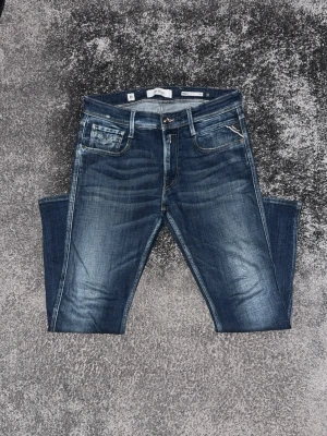 Mörkblå slim fit jeans med slitningar - Snygga mörkblå slim fit jeans med lätt slitna detaljer och kontrastsömmar. Klassisk femficksmodell med dragkedja och knapp. Jeansen har en cool tvättad look och passar perfekt till en avslappnad stil.