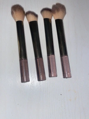 Set med fyra sminkborstar - Fyra sminkborstar med mjuka, täta borst i beige och ljusbrunt. Perfekta för applicering av puder, rouge,bronzer eller highlighter. Säljs som ett set.
