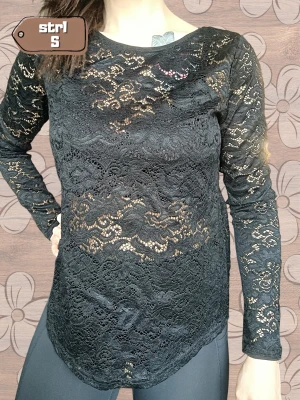 Svart Spetstopp KappAhl S | Lace Top -  Elegant svart spetstopp från KappAhl med vackert blommönster och lång ärm. Spetsen är lätt transparent och toppen har en fin, feminin look. 🖤 🖤 Svart spetstopp 🌸 Vackert blommönster i spets ✨ Lång ärm 👚 Storlek: S 🧵 Material: 94 % nylon, 6 % elastan 📌 Märke: KappAhl 📸 Skick: Mycket bra skick