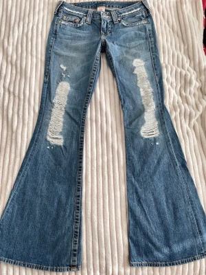 Vintage slitna True Religion jeans  - Jättesnygga flared/bellbottom True religion jeans med slitningar framtill, strl 28, sitter som S 💗//  midja 38cm tvärsöver, innerbenslängd 84cm, benöppning 29,5cm, grenhöjd 18cm 