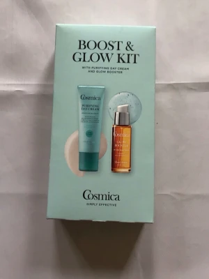 Cosmica Purifying Day Cream & Glow Booster - Set med Cosmica Purifying Day Cream (50 ml) och Glow Booster (30 ml). Dagkrämen kommer i en ljusblå tub och boostern i en genomskinlig pumpflaska med orange innehåll. Perfekt för dig som vill ha återfuktad och strålande hud.