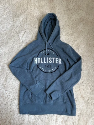 Blå hoodie från Hollister - Säljer denna blå fina hollister hoodie för att den inte kommer till användning. Den är i storlek S, skulle säga att den passar dom mellan Xs-S typ. Har inte använt den jättemycket, så den är inte sliten. Jag säljer denna för 300kr💗 Pris kan diskuteras💗