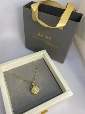 Guldigt halsband med solhänge - Snyggt halsband i guldfärg med ett solformat hänge dekorerat med gnistrande stenar. Kedjan har en elegant länkdesign och hänget ger ett lyxigt intryck. Ej använd utan kommer från min small business.