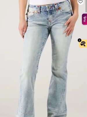 Ljusblå bootcut jeans från true religion  - Säljer dessa otroliga jeans från true religion med röda detaljer. Dom är k storlek M säljer då jag inte får användning av dom köpta för 2500