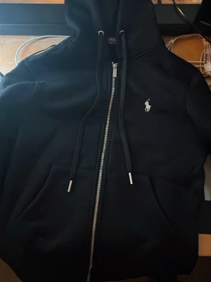 Polo raulph lauren zip hoodie - Svart Polo raulph lauren zip hoodie. Storlek S men sitter som xs. Helt ny inte använd. Säljer den eftersom den var för liten för mig.