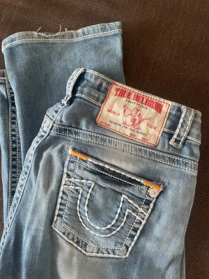 True religion low waist bootcut - Lågmidjade ljusblå jeans från true religion, det står ingen storlek med de passar som 36-38. Passar mig i längd som är 178 cm.