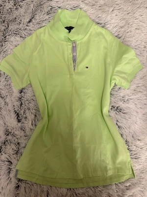 Ljusgrön pikétröja Tommy Hilfiger - Snygg ljusgrön pikétröja från Tommy Hilfiger med korta ärmar och krage. 