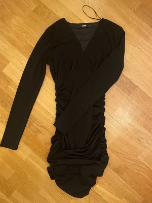 Svart klänning - Svart, elegant klänning köpt från BikBok. Knappt använd då det inte riktigt är min stil. Storlek S, med dragkedja där bak och den är ”rouched” på sidorna och bak. 