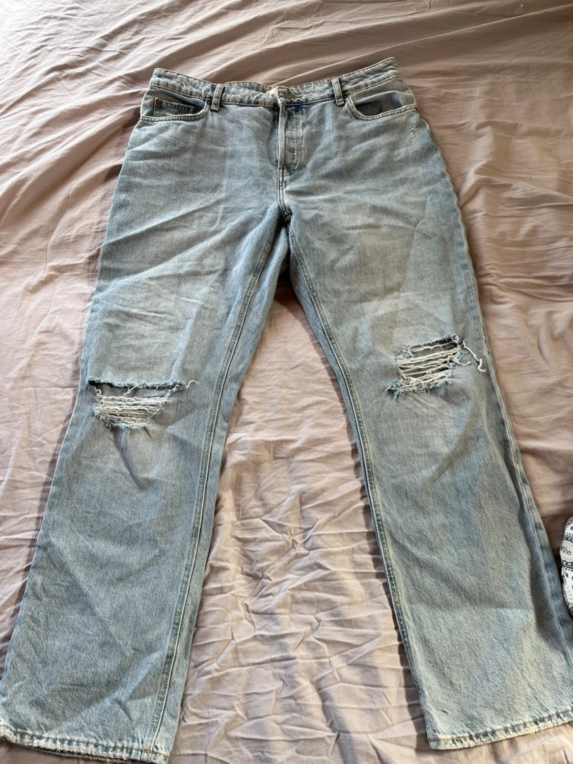 Ljusblå slitna raka jeans