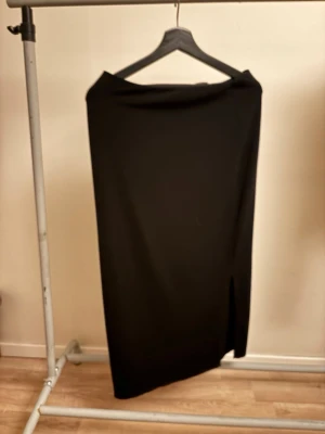 Svart långkjol med slits - Svart långkok med slits på sidorna. Köp gärna postar så snabbt som möjligt