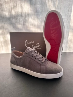 Grå Christian Louboutin sneakers - Helt nya sneakers från Christian Louboutin i färgen grå. Vit sula utan spikar i storlek 48. Inga skador eller missfärgningar. Skriv vid frågor och funderingar. Skickar snabbt 📦🚚💨