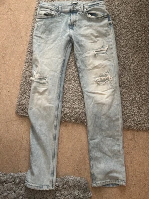 Zara Jeana  - Säljer ett par ljusblå jeans med slitningar och hål på båda benen. . Materialet är denim i bomull. Priset kan diskuteras🙏🏾