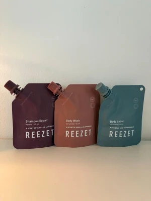 ReeZet resekit: schampo, tvål & lotion - Praktiskt resekit från ReeZet med tre mjuka påsar: Shampoo Repair (vinröd), Body Wash (brun) och Body Lotion (blågrön). Varje påse rymmer 50 ml och har skruvkork. Doft av vanilj, lavendel, salvia och kamomill. Perfekt för resan eller gymväskan.