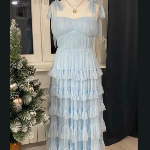 Ljusblå balklänning - Jätte fin ljusblå balklänning med rosetter vid axlarna!                                                                  Längd: 147 cm Midja: 33 cm Från armhåla till armhåla över byst: 39 cm Den har dragkedja i ryggen. Inga skavanker. Standasdstorlek S  Första bilden är från personen jag köpte den av men endast jag har använt den! Jag är ca 166 och sydde upp klänningen lite men den är inte uppsydd längre! Pris kan diskuteras🙌