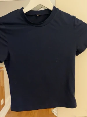 Mörkblå basic t-shirt XS från Shein  - En enkel och stilren mörkblå t-shirt i storlek XS. T-shirten har rund halsringning och korta ärmar, perfekt för en clean och avslappnad look. Tillverkad i mjuk bomull som känns skön mot huden.