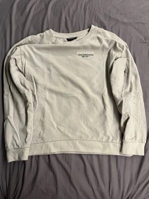 Beige sweatshirt med tryck - Säljer en beige sweatshirt från BRAND WITH ME med broderad text 'keep it simple urban skateboarding' och en skateboard på bröstet. Tröjan har rund halsringning, långa ärmar och är gjord i mjuk bomull. Perfekt för en avslappnad streetwear-look.