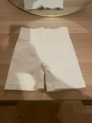 Vita shapewear shorts, seamless S - Vita shapewear shorts i ribbat material med hög midja. Tillverkade av 92% polyamid och 8% elastan för en stretchig och bekväm passform. Sömlös design som ger en slät siluett under kläderna. Perfekta för att forma och ge stöd.skriv för fler bilder, pris kan diskuteras!💗