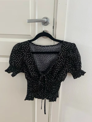 Svart prickig blus med knyt - Super söt blus som är alldeles för liten för mig, vet tyvärr inte vart den är köpt då den är köpt utomlands🌸   Storlek XS Knytning vid bröstet Smått puffärm  Räfflad vid magen Har inga defekter