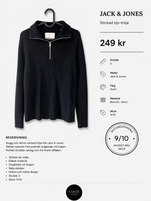 Svart stickad zip-tröja Jack & Jones - Svart stickad zip-tröja från Jack & Jones i ribbat material med dragkedja vid kragen. Tröjan har raka detaljer och en stilren, tidlös design. Tillverkad i bomull och akryl, perfekt för dig som gillar enkel men snygg stil.