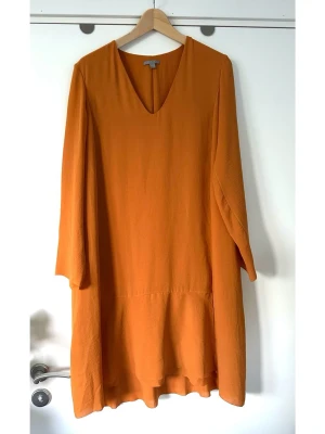 COS - Orange loose klänning med v-ringning - storlek 42 - Härlig klänning från COS i storlek 42 i en vacker orange nyans. Stilren modell med långa ärmar V-ringning. Designad med en lös passform som övergår i en volang nedtill, vilket ger ett elegant fall. Lätt att både styla upp för fest eller styla med för vardag/jobb. Nypris 1650:-. Mycket gott skick, som ny!