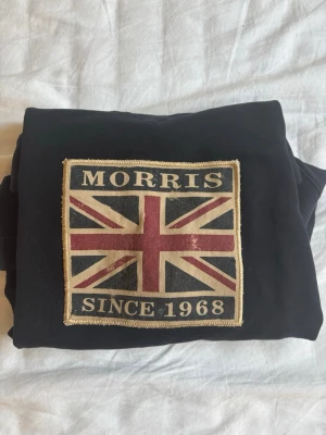 marinblå  sweatshirt från Morris - Cool marinblå sweatshirt från Morris med stort Union Jack-tryck och texten 'Morris Since 1968' på bröstet. Tröjan har rund halsringning och långa ärmar. Perfekt för dig som gillar klassisk brittisk stil.