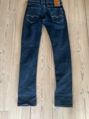 Mörkblå raka jeans från Replay - Säljer ett par mörkblå jeans från Replay med raka ben och kontrastsömmar. Jeansen har snygga detaljer på bakfickorna perfekta för en stilren och avslappnad look. Storlek: W29 L32 modell: grover replay hyperflex