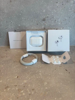 Apple AirPods Pro 2nd Gen USB-C 1.1 - Apple AirPods Pro (2nd generation) med USB-C laddningsetui. Trådlösa in-ear hörlurar i vit färg med silikonproppar i olika storlekar, brusreducering och laddkabel. Snygg och kompakt design, perfekt för musik och samtal.