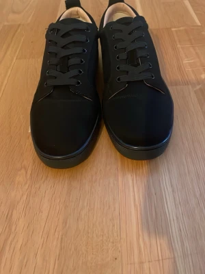 Svarta låga sneakers i textil - Stilrena svarta sneakers med lågt skaft och klassisk design. Skorna har svart textilöverdel, matchande svarta skosnören och en svart sula. Perfekta för dig som gillar minimalistisk och clean stil. Passar till det mesta och är lätta att matcha. Har också påsen för båda sko o den normal påsen för att lägga båda skor, dålig sula lite skador 