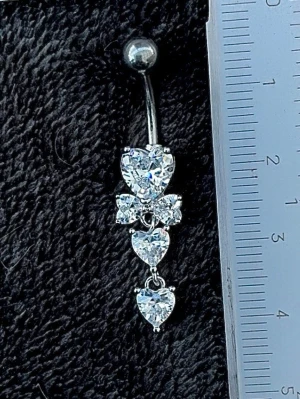 NY oanvänd Navelpiercing med hänge | Kirurgiskt stål | Hjärtan och vita stenar - 💕30% Bundle-rabatt vid köp av minst 2 artiklar. ⭐️NY oanvänd piercing i kirurgiskt stål; rostfritt och säkert för läkta piercingar.                               📏MÅTT ⭕️Stavens längd: 10mm ⭕️Stavens tjocklek: 1,6mm ⭕️Smyckets totala längd: 40mm                                                                         🤍Färger: Silver och vit                                                            💌Skickas spårbart via Plick SafePay.