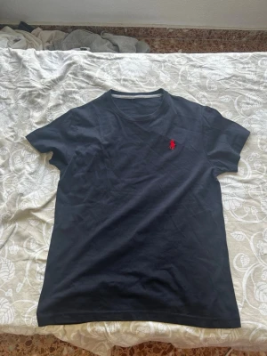 Svart Ralph Lauren T - Shirt - Säljer en svart Ralph Lauren T-shirt. Den är stilren och perfekt för dig som gillar en enkel och tidlös stil. Tröjan är i storlek S och passar personer runt 175 cm. Den är mycket skön och bekväm att bära.  Jag har även samma tröja i storlekarna S–XL samt i färgerna svart, marinblå, grå och vit.  Hör gärna av dig om du har några frågor eller är intresserad.  Med vänliga hälsningar, William 🙌