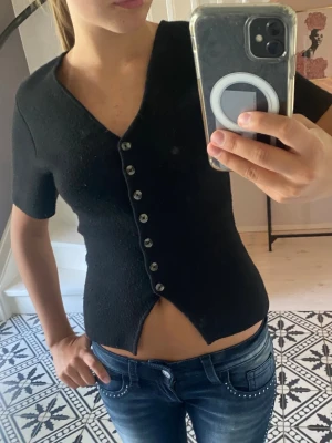 Svart v-ringad topp med knappar - Säljer då den inte kommer till användning. Kontakta för fler bilder. 