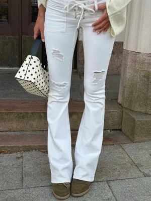 Low waist jeans - Jättefina vita low waist jeans från Ginatricot med snörning i storlek S. Prislapp kvar så helt nya endast testade. Är i modellen ”Pleated tie jeans tall”. Helt slutsålda i buktik o online❣️